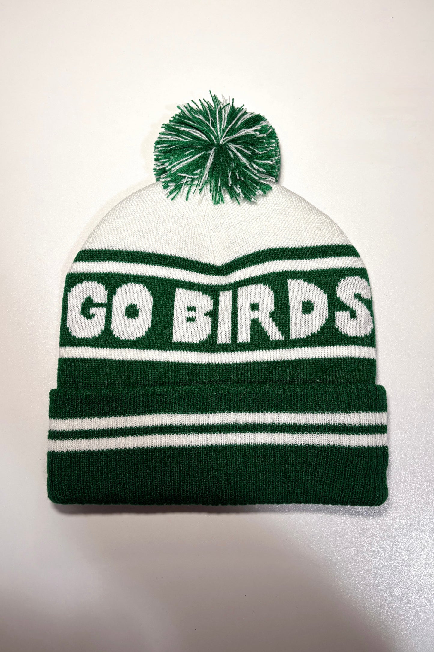 Green and white beanie with 'GO BIRDS' text and pom-pom on a white background