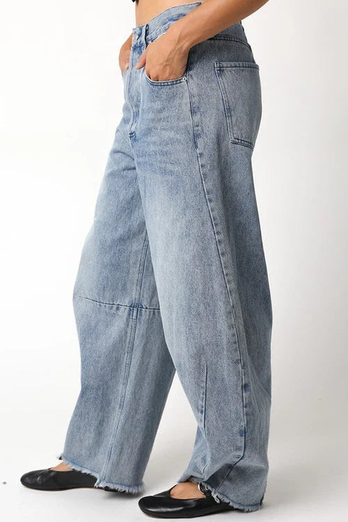 Person wearing light blue wide-leg jeans on a white background