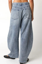 Back view of Ingrid light-wash barrel jeans showing two patch pockets, back leg seams, and frayed hems.

