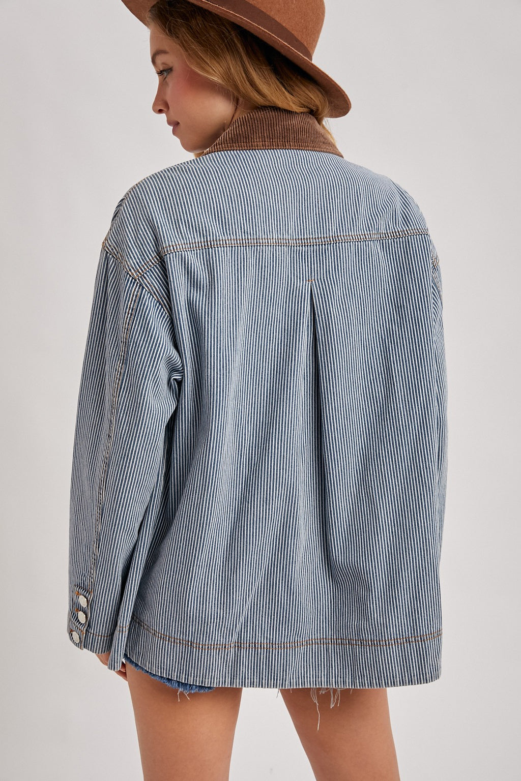 Back view of the Derby striped denim barn jacket showing the brown corduroy collar, center pleat, and contrast stitching.

