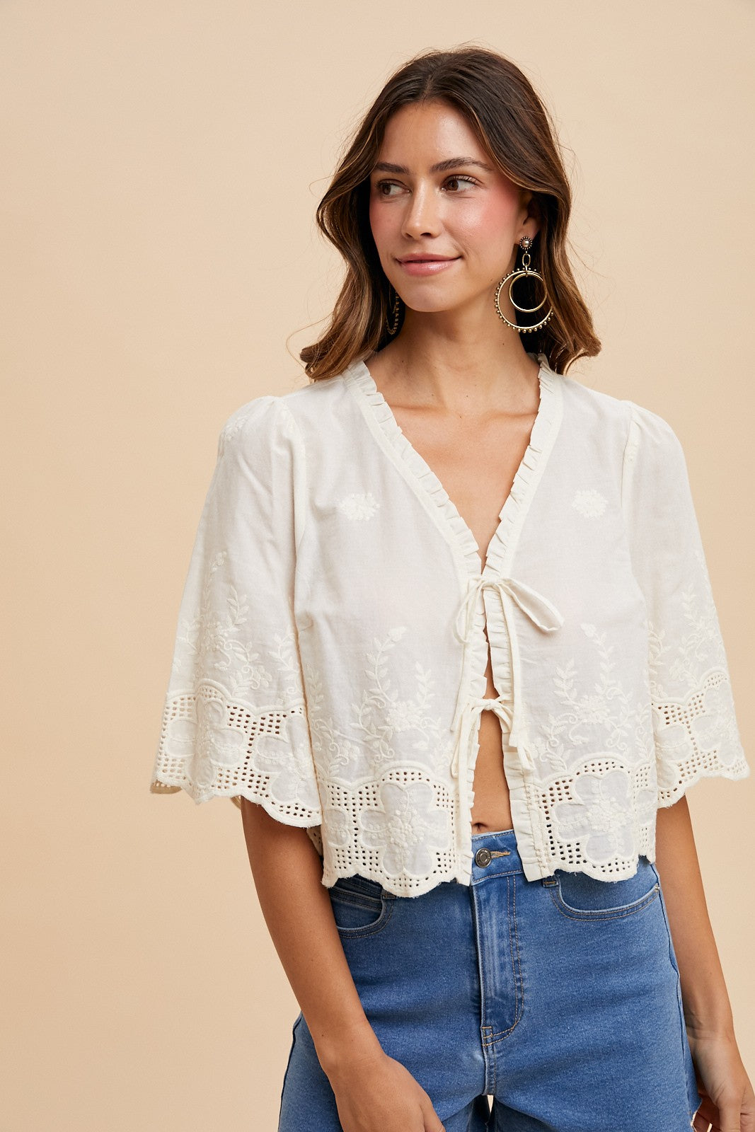 Ivory cotton tie front blouse showing lace details and scalloped sleeve edges