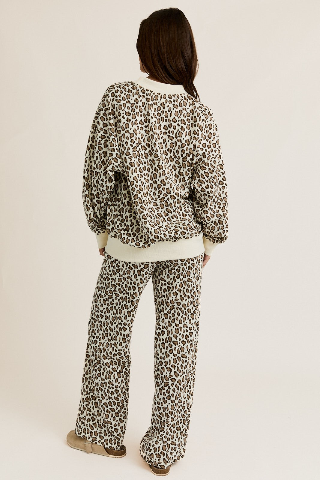 Person wearing a leopard print outfit on a beige background