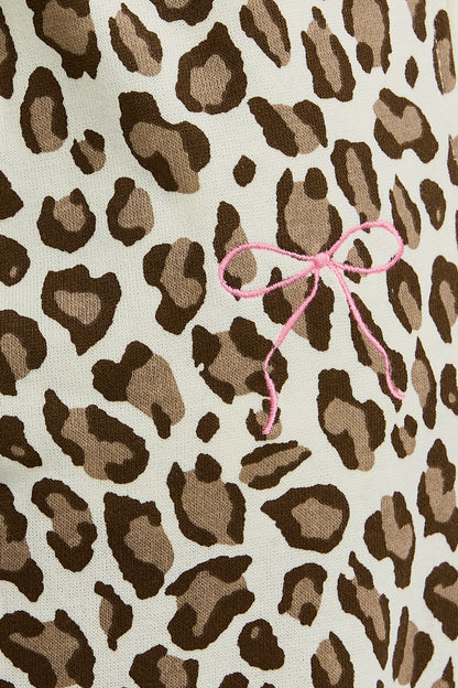 Leopard print fabric with a pink bow on a beige background