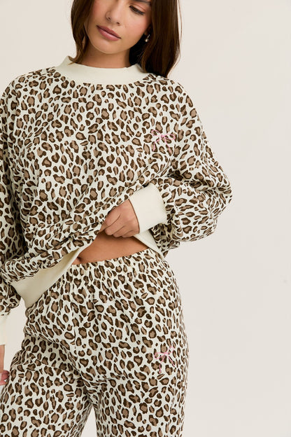 Person wearing a leopard print outfit on a plain background