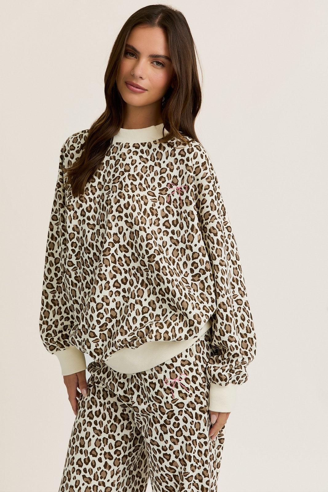 Woman wearing a leopard print outfit on a beige background