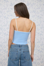 Back view of the Elsie light blue cropped tank showing white adjustable straps and a straight back neckline, styled with jeans.

