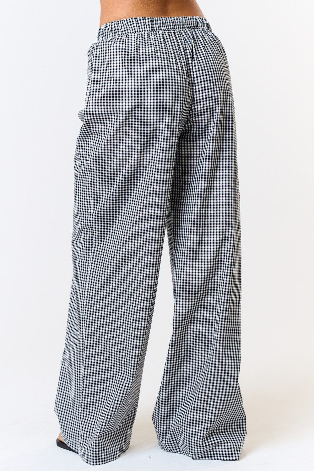 Back view of black-and-white gingham boxer pants showing the gathered waistband and relaxed wide legs.


