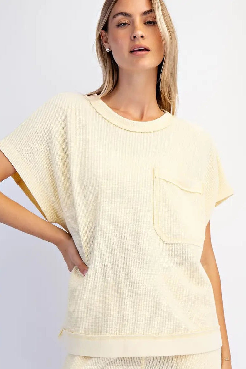 Woman wearing a light yellow outfit with a plain background