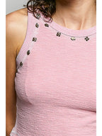 Close-up of the Sylvie pink tank top showing decorative neckline studs and textured knit fabric
