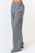 Side view of gingham boxer pants showing the elastic waistband and loose, wide-leg silhouette against a white background.

