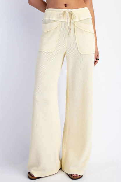 Light yellow wide-leg pants on a plain background