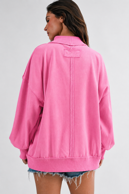 Person wearing a pink sweatshirt on a plain background