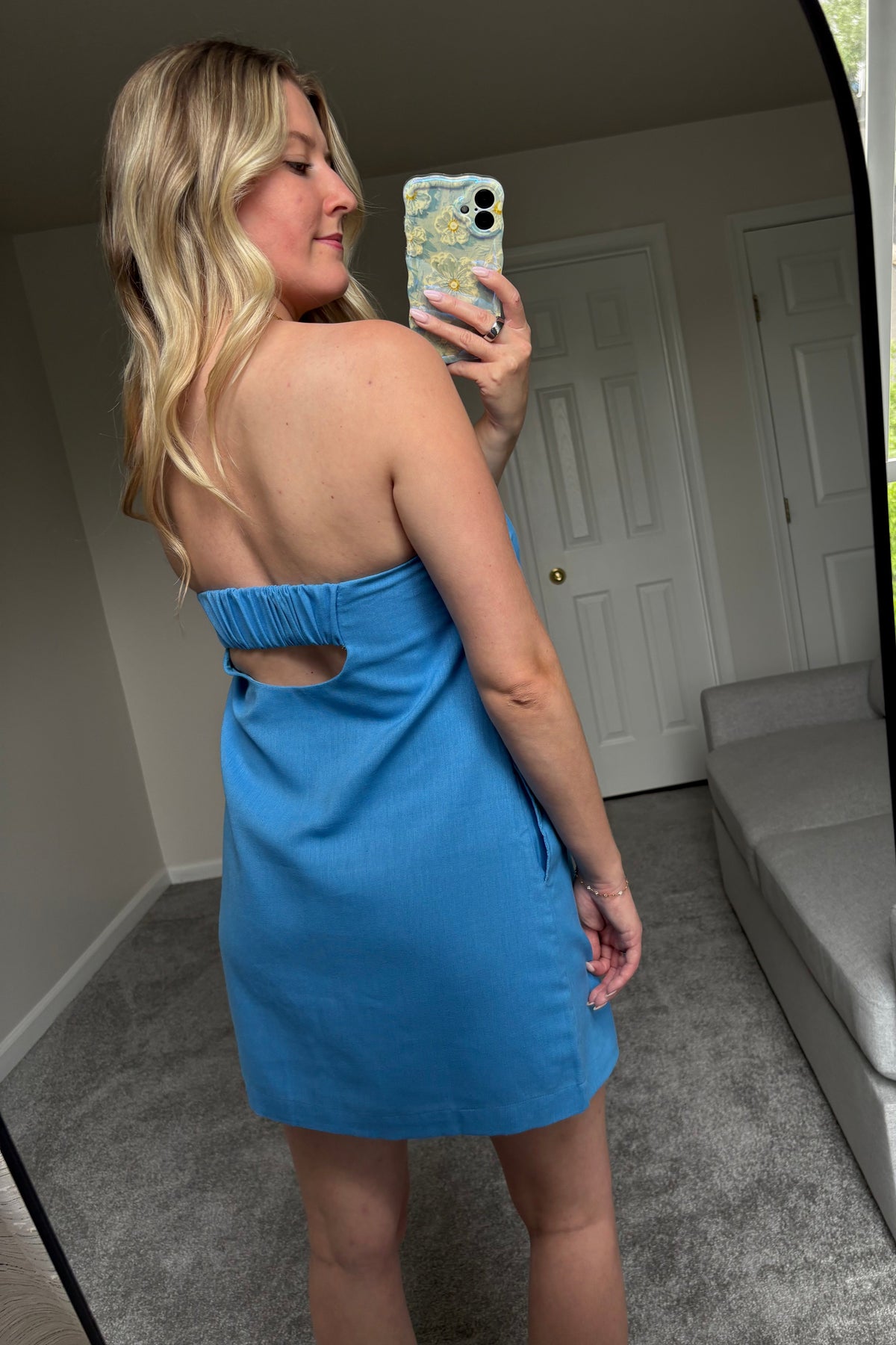 Back view of the Santorini blue mini dress showing the cutout beneath a gathered elastic strap.

