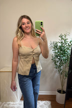 Front view of the Carli beige button-front tank showing its fitted shape and open split hem over blue jeans.

