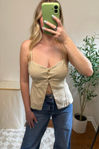 Close-up of the Carli tank showing its gathered button-front bodice, tailored seams, and split hem.

