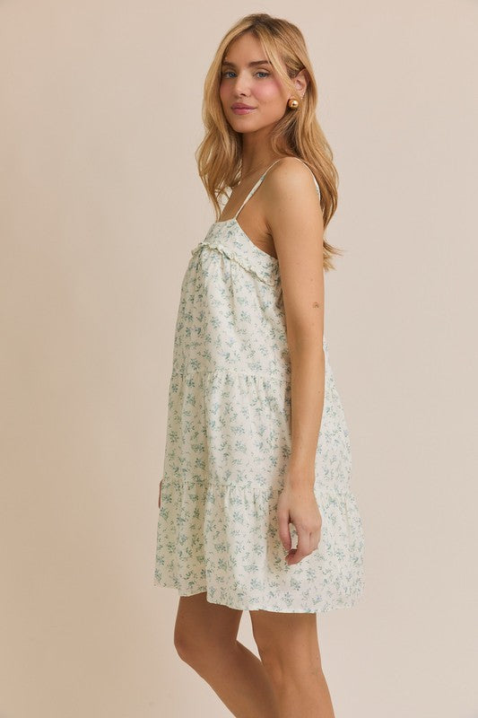 Side view of the Meadow Muse floral mini dress showing its flowy silhouette, thin straps, and above-the-knee hem.

