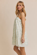 Side view of the Meadow Muse floral mini dress showing its flowy silhouette, thin straps, and above-the-knee hem.


