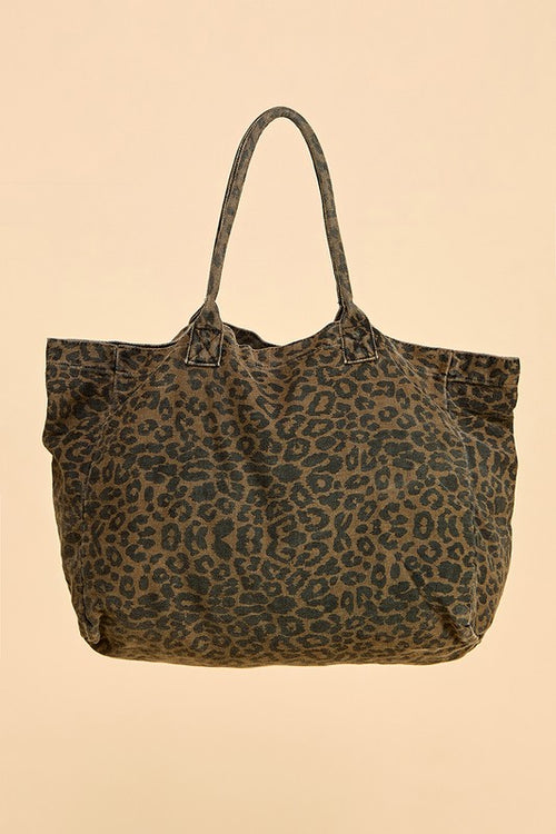 Front view of the Cheetah Girls animal print tote bag showing its broad shape, long handles, and all-over dark spotted pattern against a peach background.

