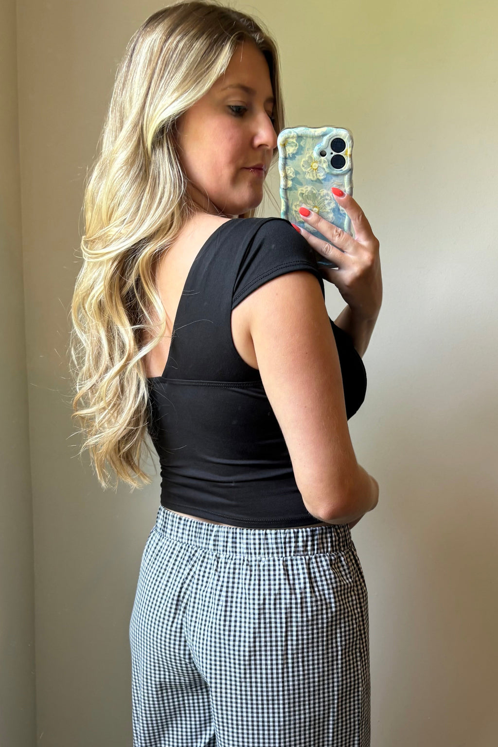 Angled back view of the Lark black crop top showing its low back neckline, cap sleeve, and fitted silhouette.

