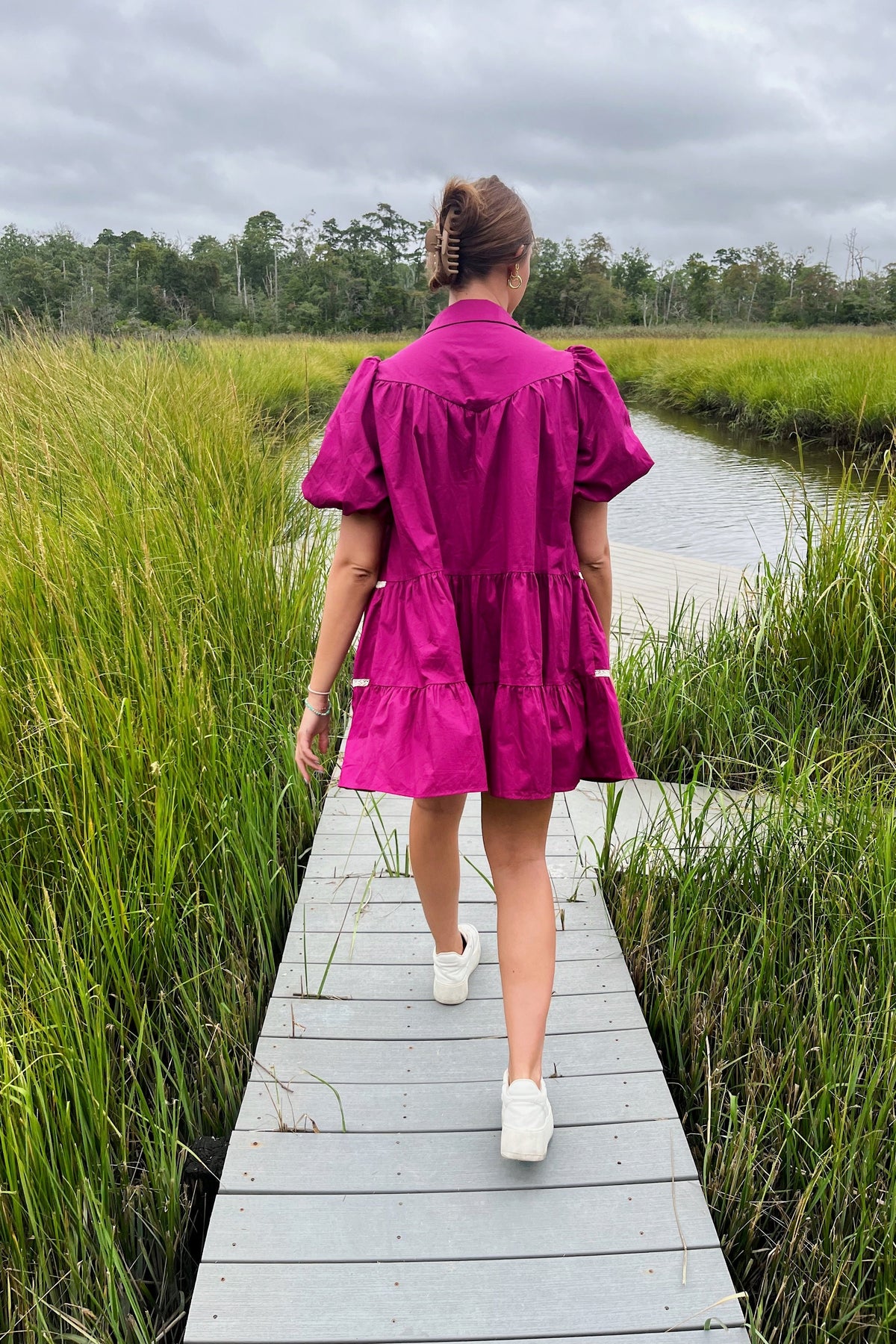 Back view of the Margaret magenta mini dress showing puff sleeves and a gathered tiered skirt.

