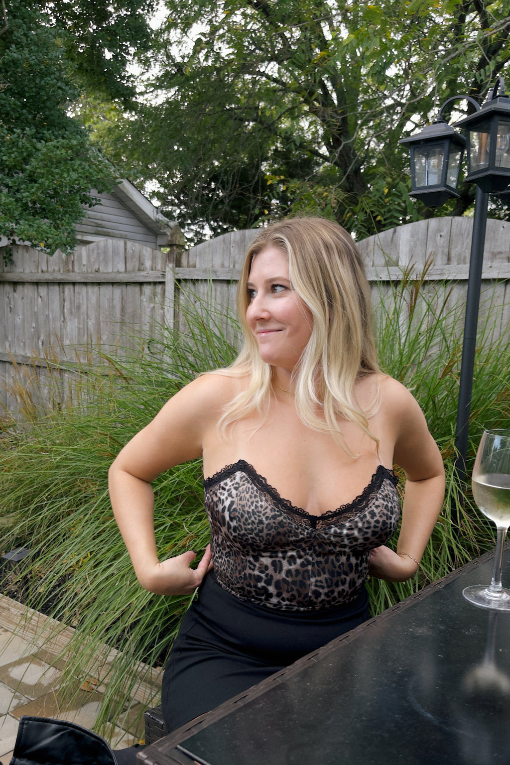 Front view of the Laney cheetah print corset top showing black lace edging and a fitted bodice, paired with a black skirt.

