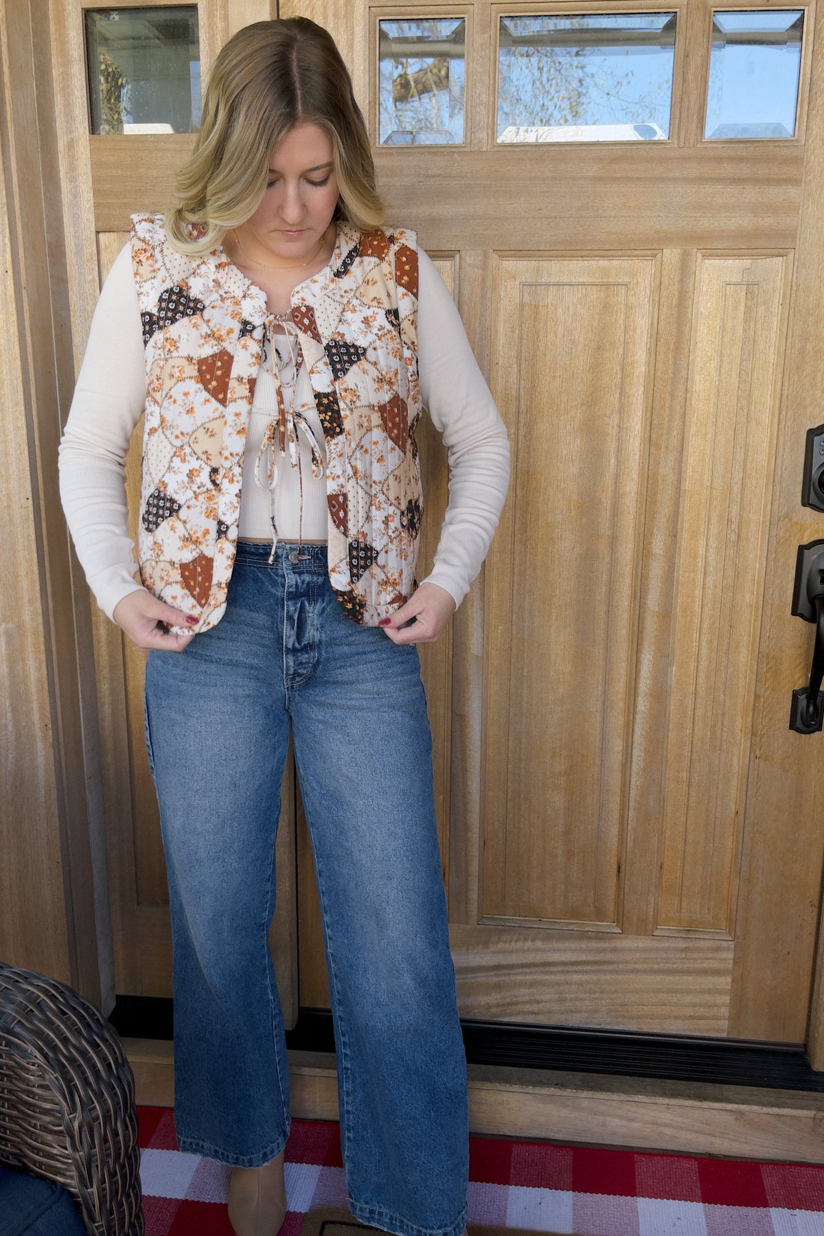 Front view of the Amber quilted vest showing its floral patchwork print, bow-tie closures, and rounded front edges.

