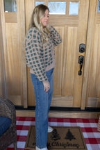 Side view of the Paige cropped checkered cardigan paired with blue jeans.

