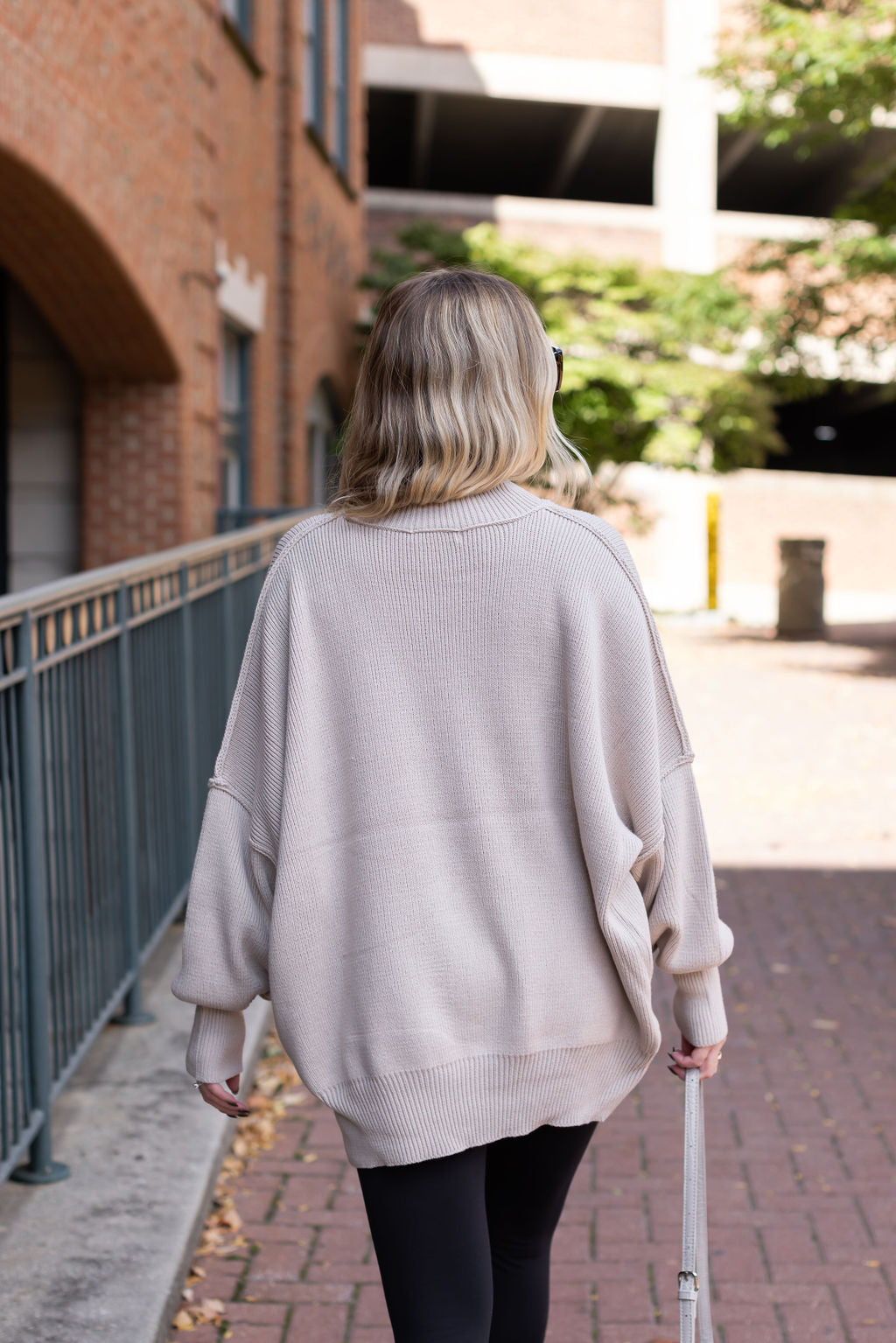 Back view of the Essential oversized sweater showing its long sleeves, ribbed hem, and center-back seam.

