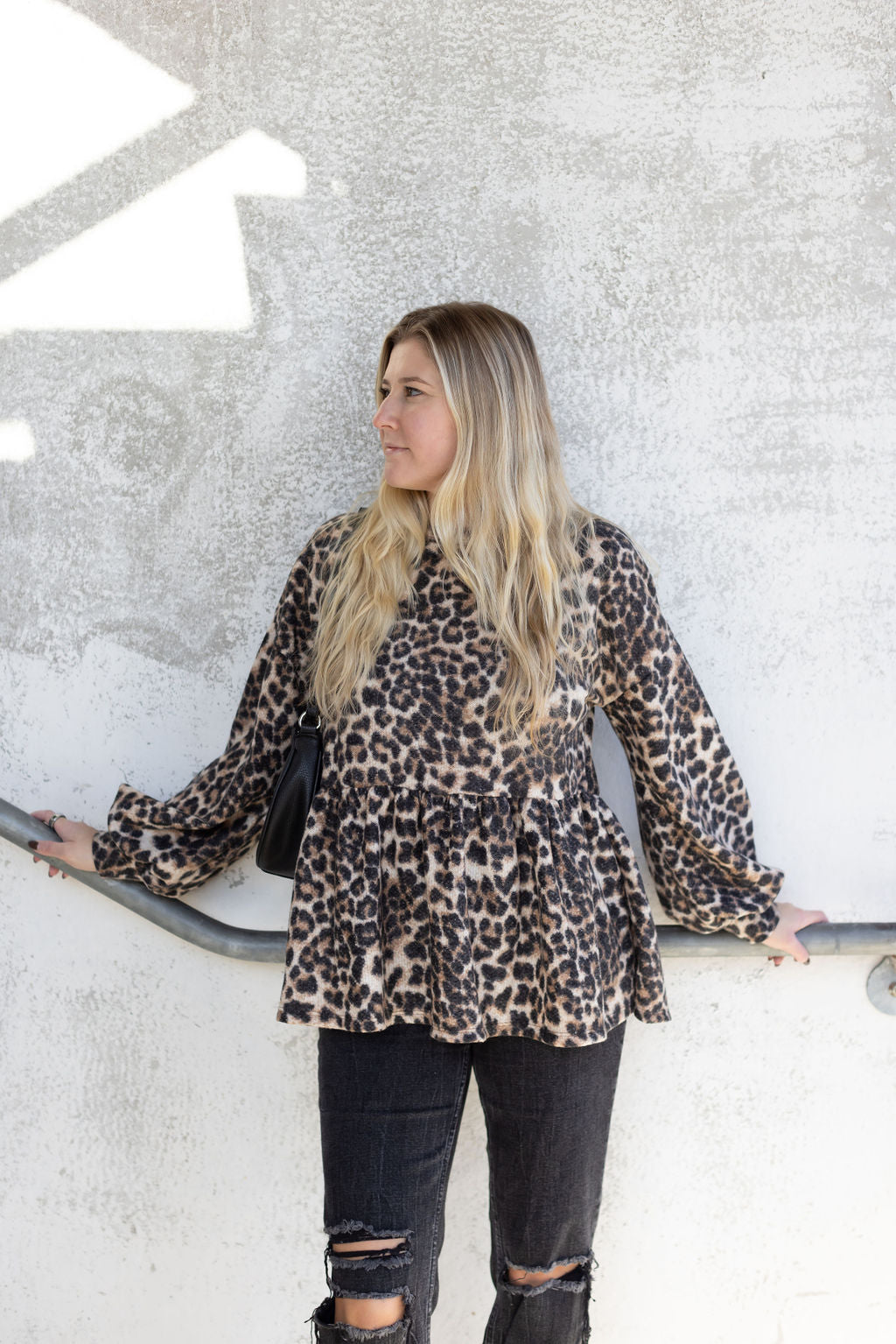 Front view of the Bianca leopard print babydoll top showing its flared hem and long gathered sleeves.

