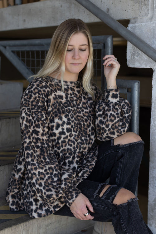 Close-up of the Bianca leopard print top showing its crew neckline, gathered waist, and bubble sleeves.

