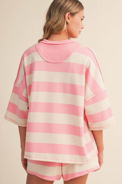 Person wearing a pink and white striped shirt and shorts on a beige background