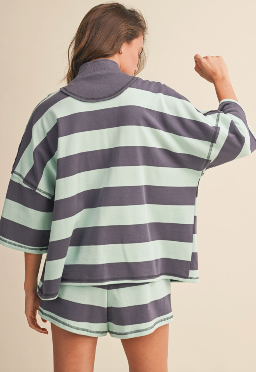 Person wearing a striped shirt and shorts set on a beige background