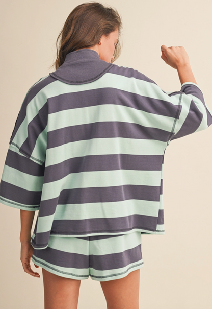 Person wearing a striped shirt and shorts set on a beige background