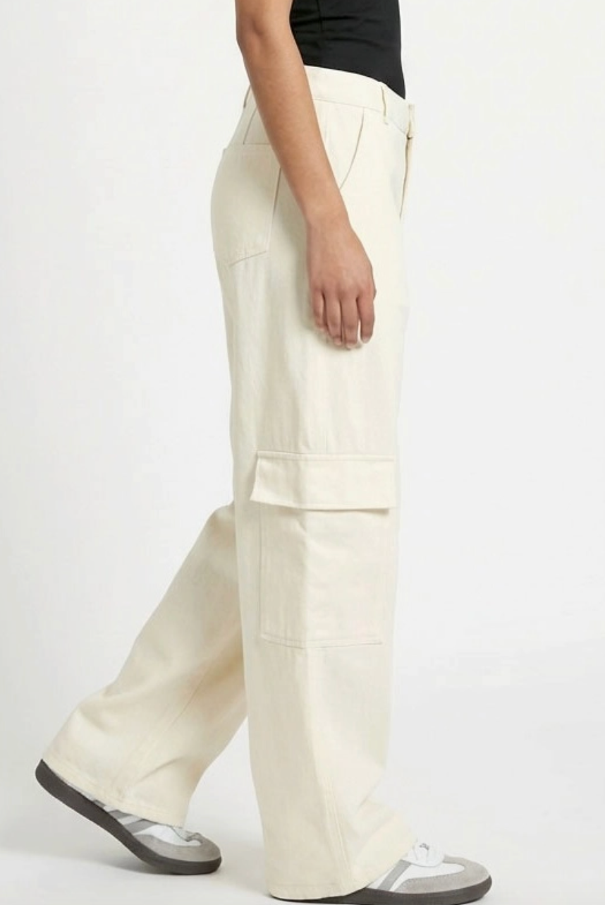 Person wearing white cargo pants on a white background
