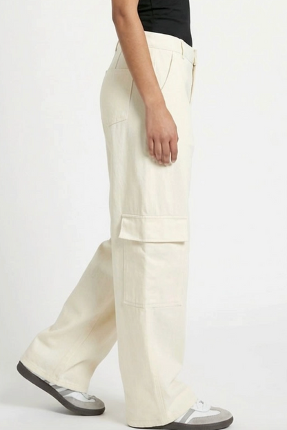 Person wearing white cargo pants on a white background