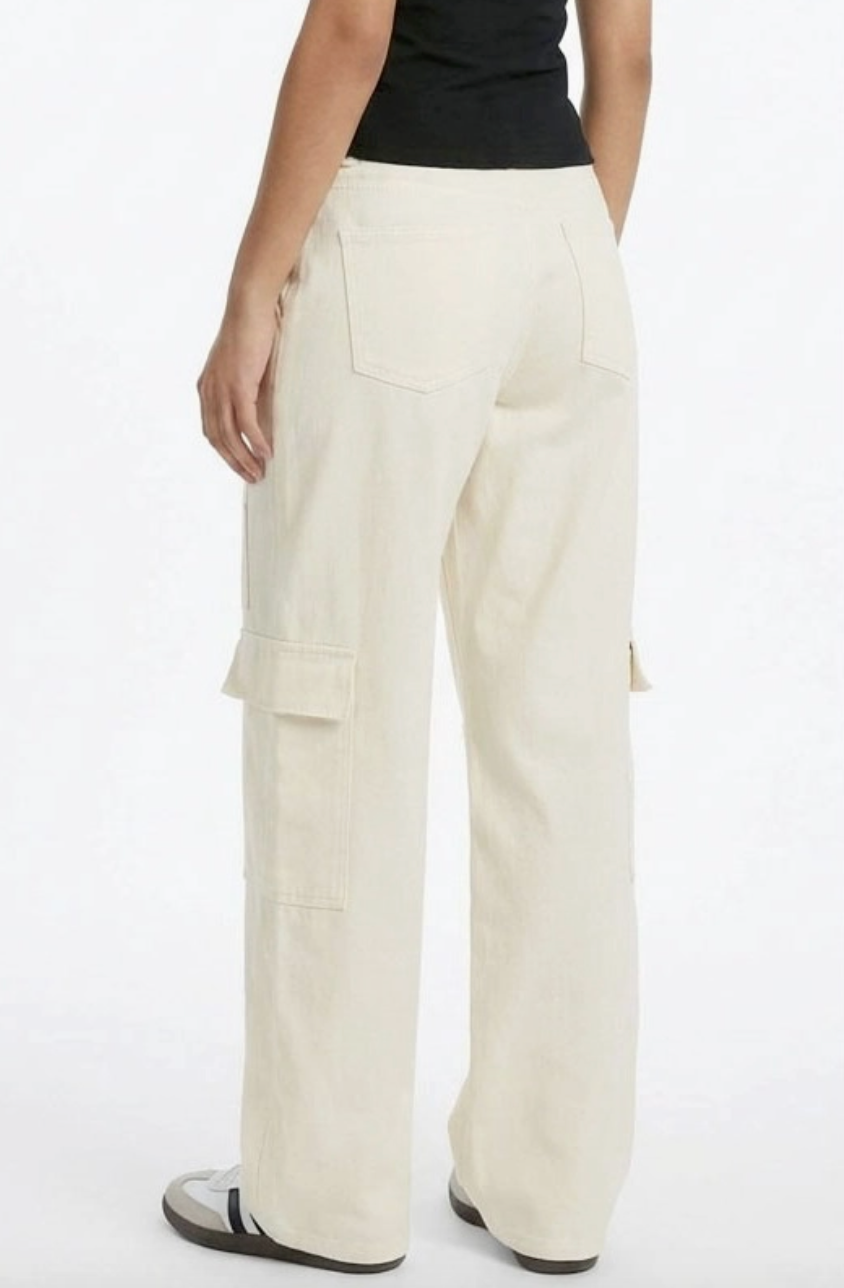 Person wearing beige cargo pants on a white background
