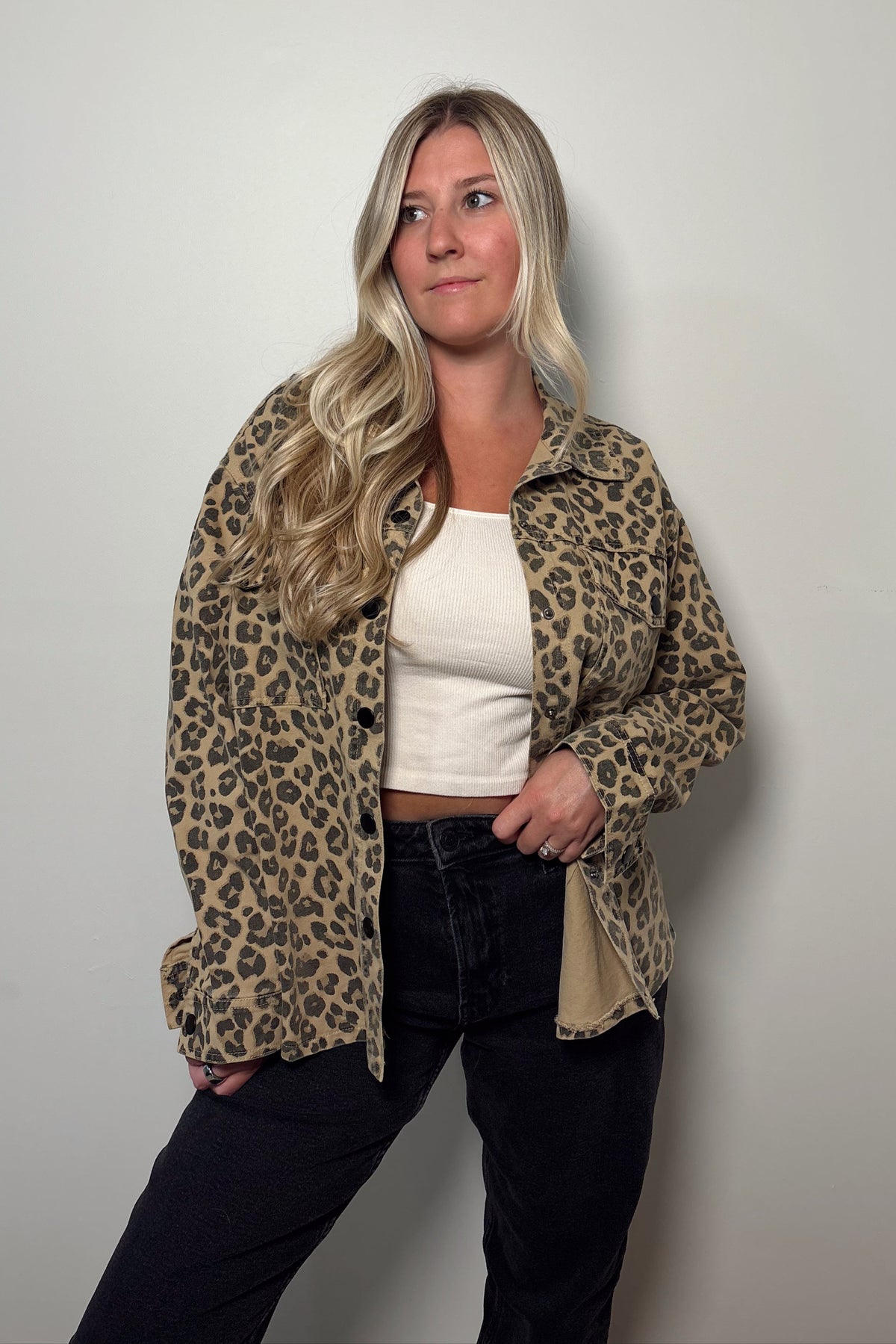 Wild Muse leopard print shacket worn open over a white tank and black jeans, showing its collar and front flap chest pockets.

