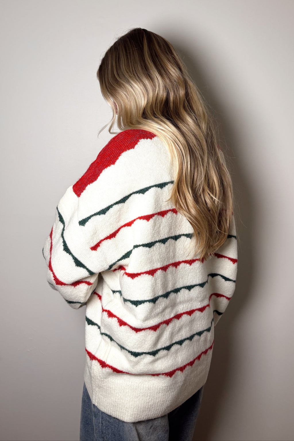 Person wearing a striped sweater against a plain background