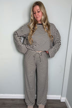 Model in the grey and cream Blair striped lounge set looking down with a hand behind her back, drawstring tie waistband visible