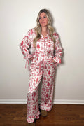 Woman wearing a red and white patterned pajama set against a plain background