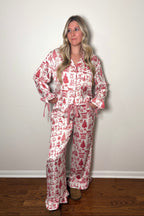 Woman wearing a red and white patterned pajama set against a plain background