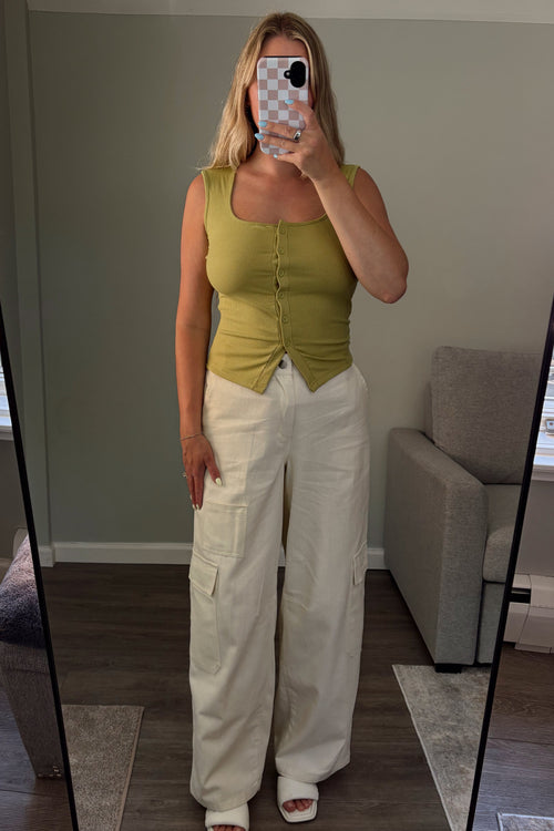  Front view of cream cotton cargo pants showing the relaxed legs and utility pockets