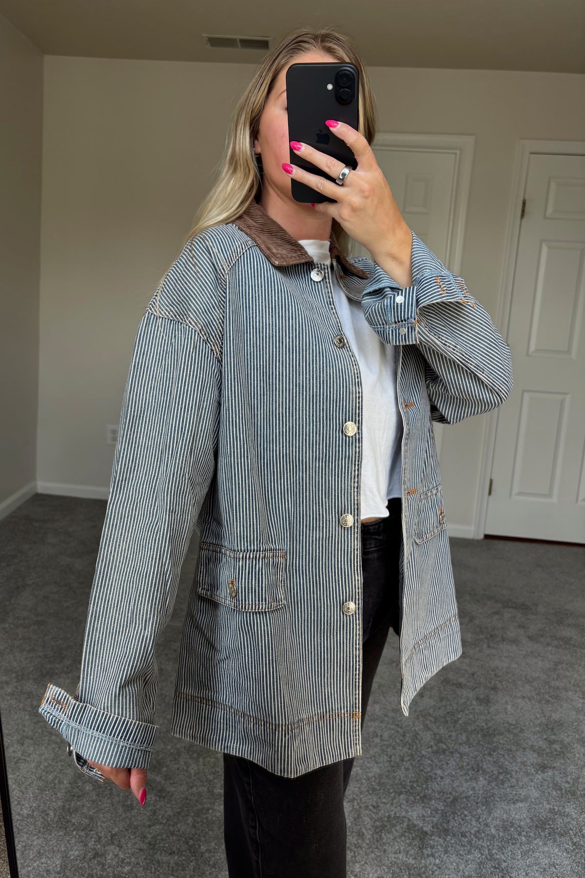Angled mirror view of the Derby striped jacket showing the dropped shoulder, rolled cuff, and large front pocket.

