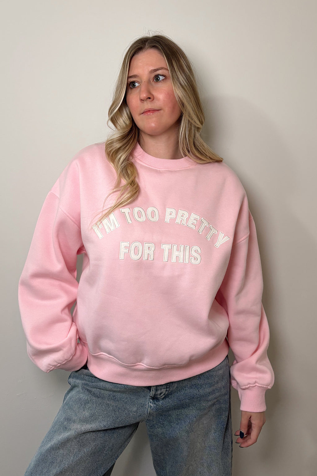 Pink Too Pretty crewneck sweatshirt with white embroidered I'm Too Pretty For This lettering, worn untucked with blue jeans.

