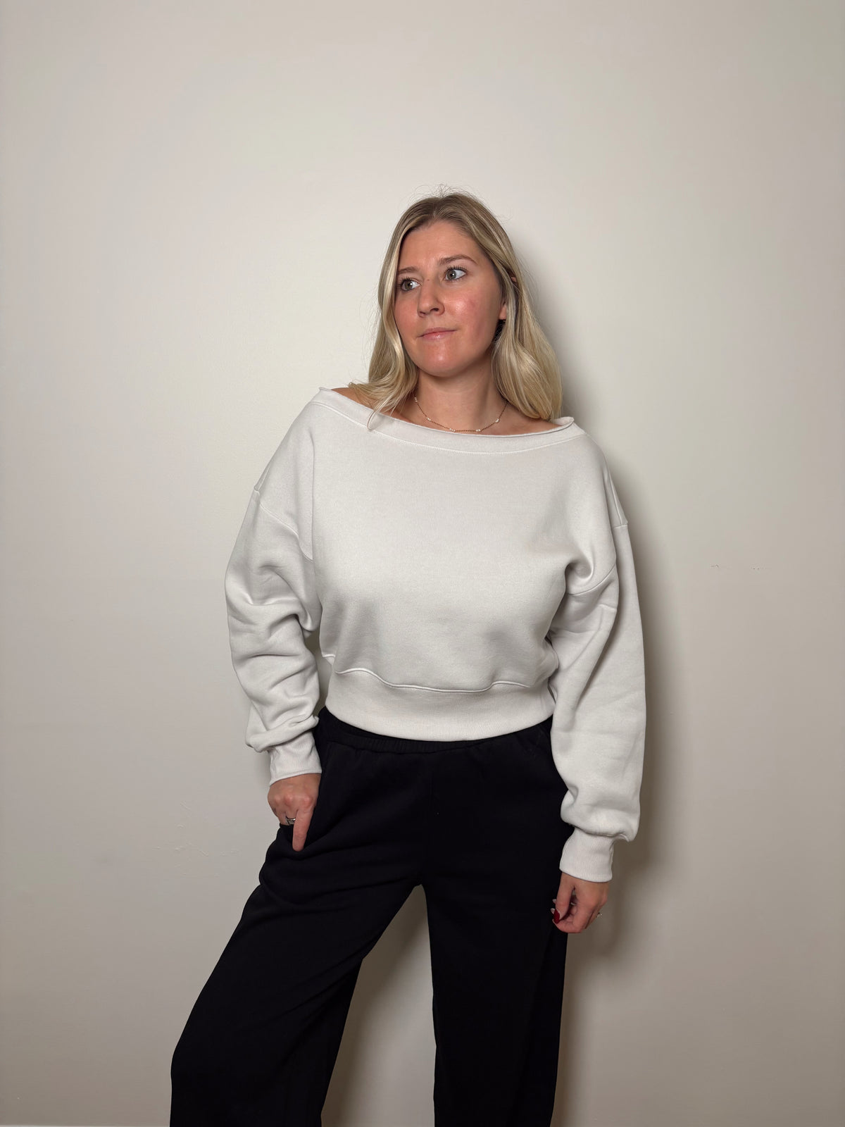 Front view of the Haven stone pullover with the neckline resting across both shoulders, showing its relaxed sleeves and ribbed hem.


