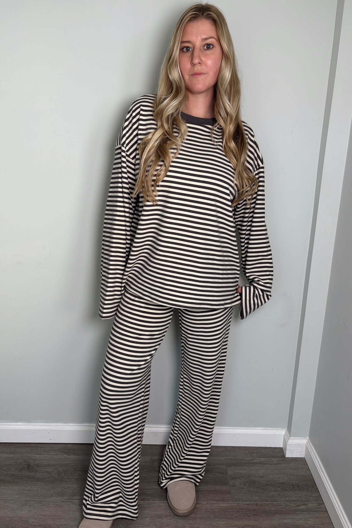 Model in the grey and cream Blair striped lounge set with a soft smile, one hand in her pocket