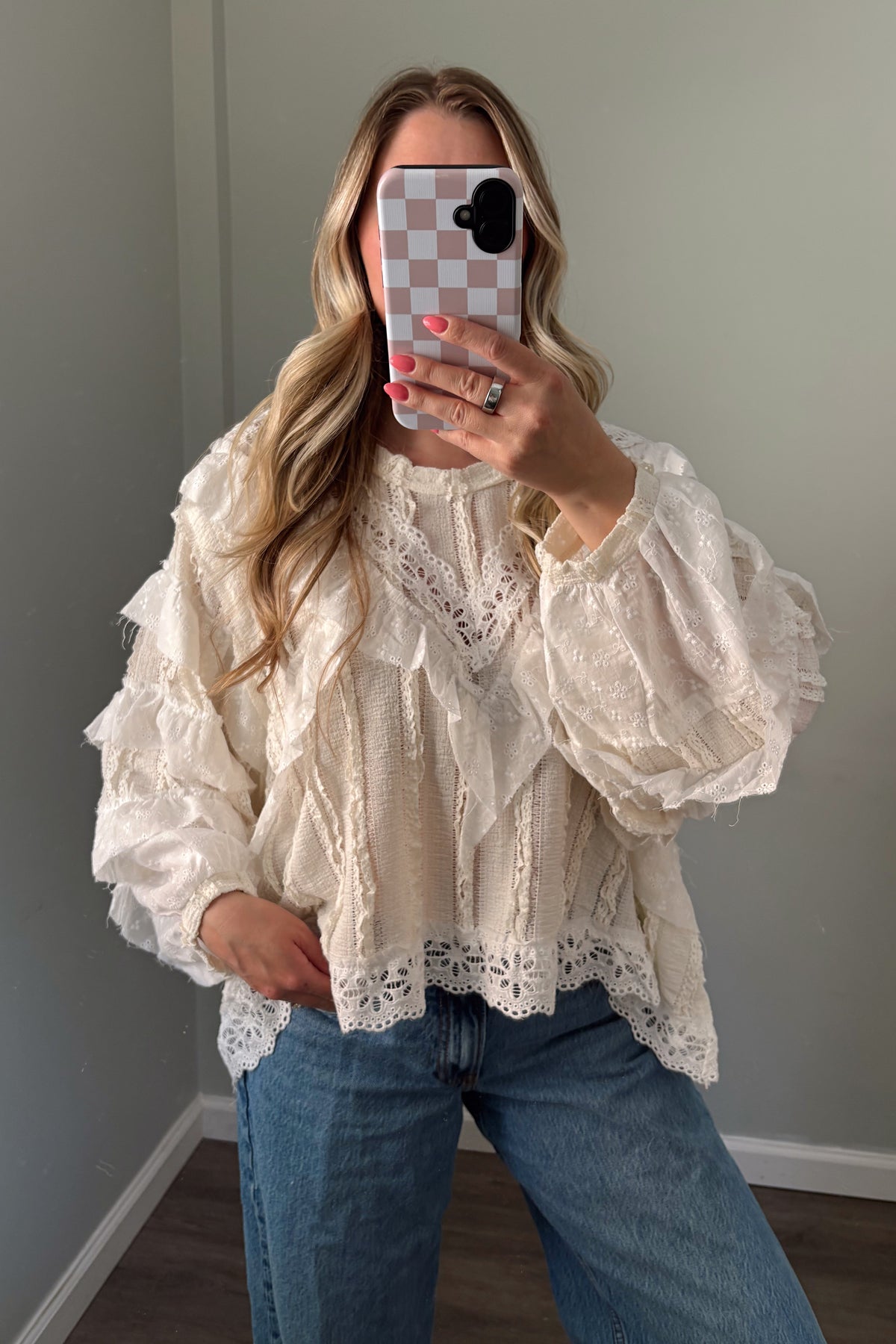 Front view of ivory ruffle blouse with a wide crew neckline and scalloped eyelet hem