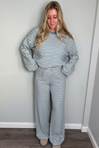 Model in the blue Blair striped lounge set looking down with a smile, drawstring tie waistband visible