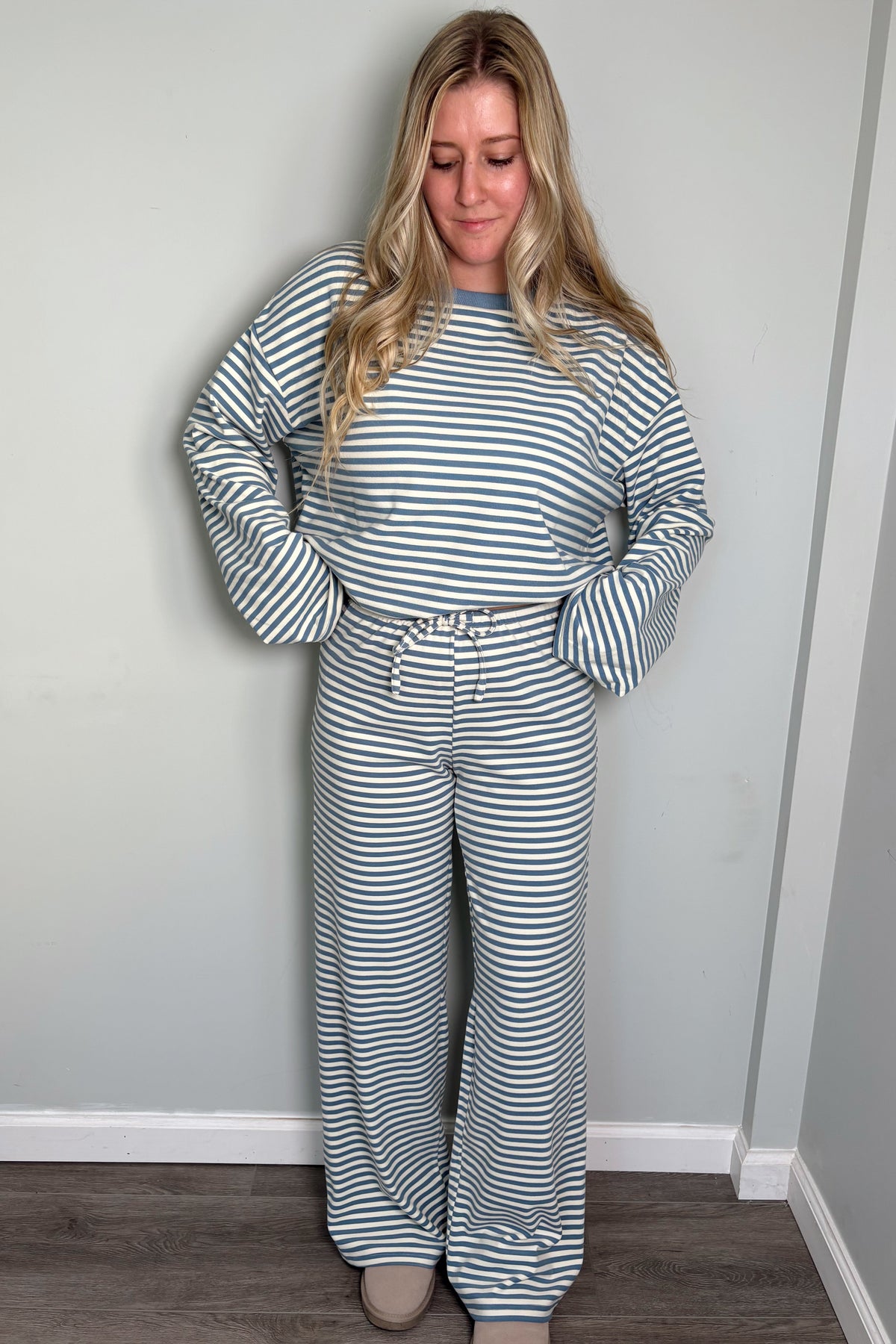 Model in the blue Blair striped lounge set looking down with a smile, drawstring tie waistband visible