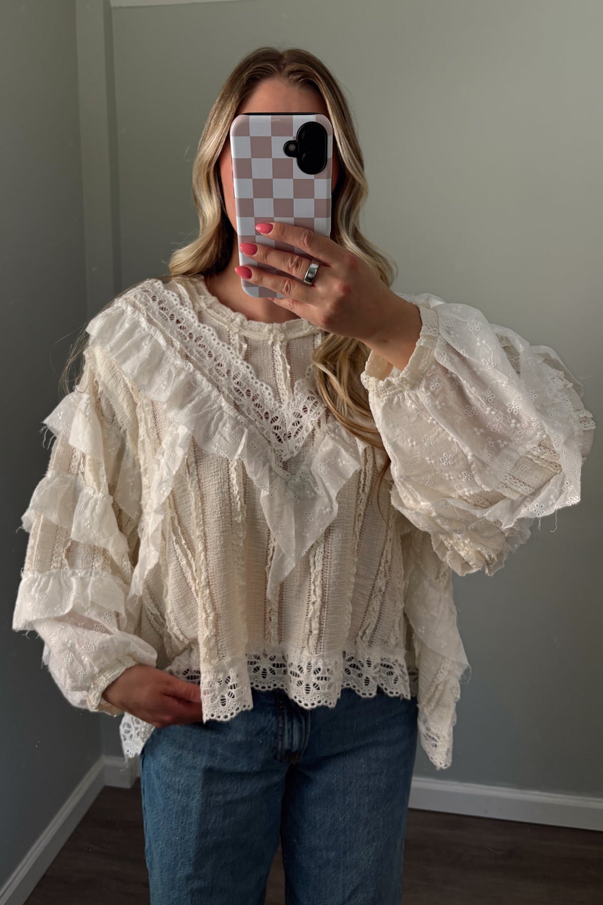 Ivory eyelet blouse showing layered front ruffles, embroidery, and a relaxed silhouette